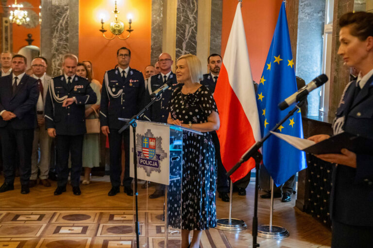Uroczystość z udziałem kieleckich policjantów, w tle polska i unijna flaga.