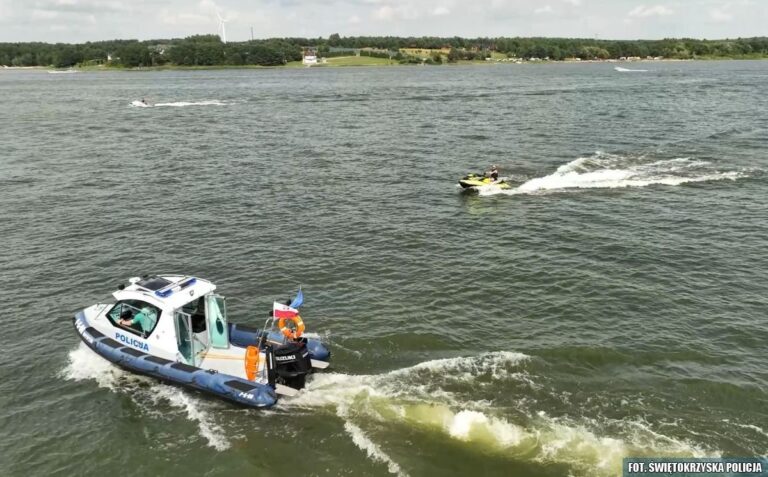 Łódź policyjna na jeziorze z osobą na skuterze wodnym