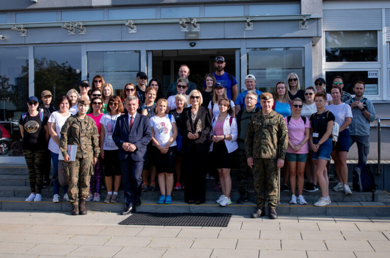 Grupa osób przed budynkiem wojskowym podczas wydarzenia