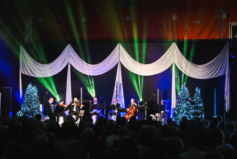 Koncert noworoczny w Chęcinach, muzycy na scenie, efekty świetlne