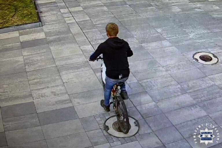 Mężczyzna na rowerze widziany z tyłu, na chodniku