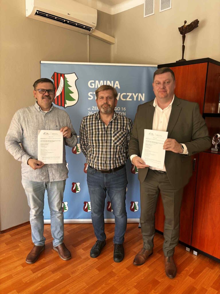 Trzech mężczyzn podczas ceremonii podpisania umowy na budowę sali gimnastycznej w Niedźwiedziu