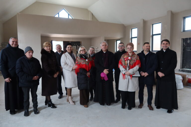 Grupa osób odwiedzająca budowę kościoła w Jaworzni