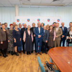 Grupa osób na tle logo Gminy Nowiny, uchwalających budżet na 2026 rok.