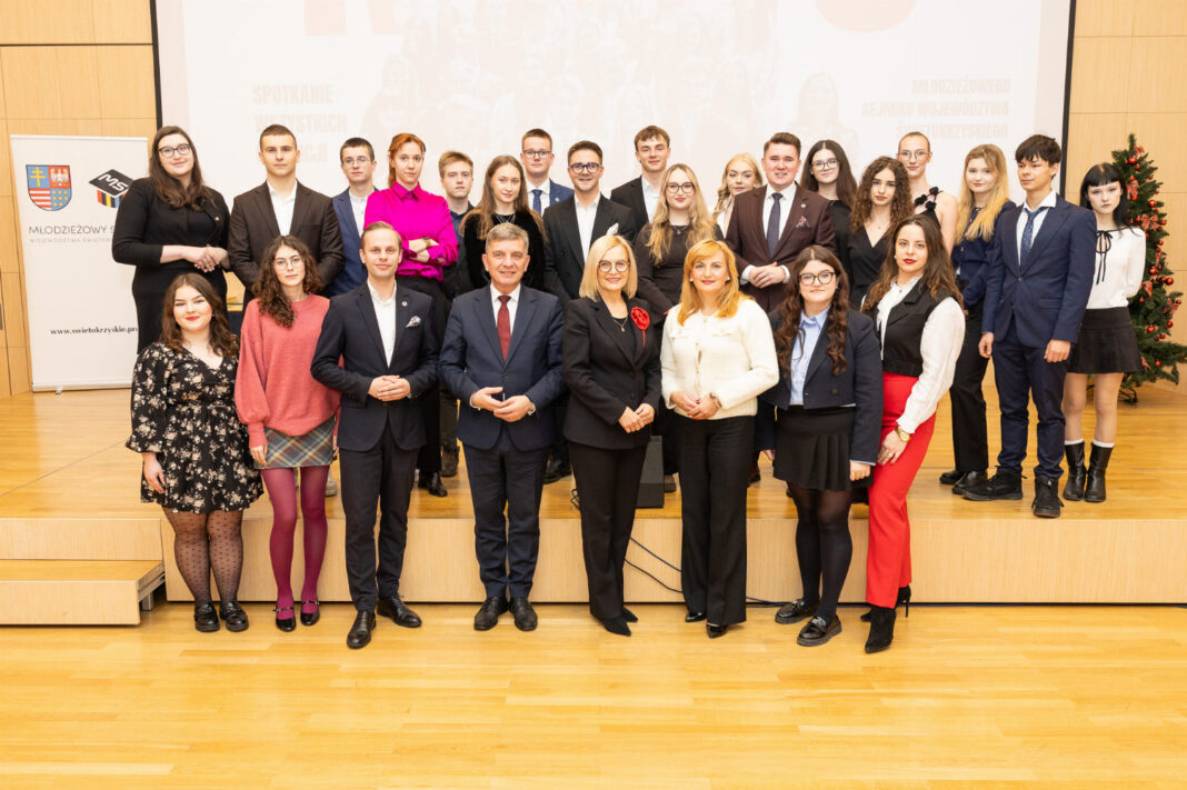 Grupa młodych ludzi stoi razem na scenie podczas posiedzenia Młodzieżowego Sejmiku.