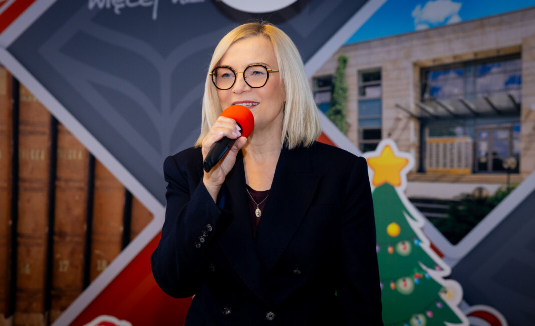 Kobieta w okularach przemawiająca do mikrofonu podczas konferencji