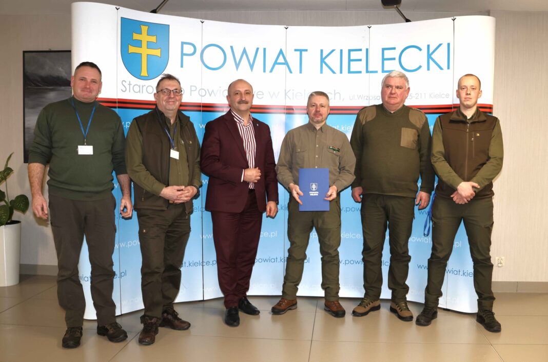 Grupa mężczyzn uczestnicząca w szkoleniu na temat klasyfikacji surowca drzewnego w Terenowym Urzędzie Powiatowym w Kielcach