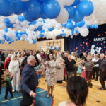 Ludzie tańczą na Międzypokoleniowym Balu Babci i Dziadka w Piekoszowie pod dekoracjami z balonów.