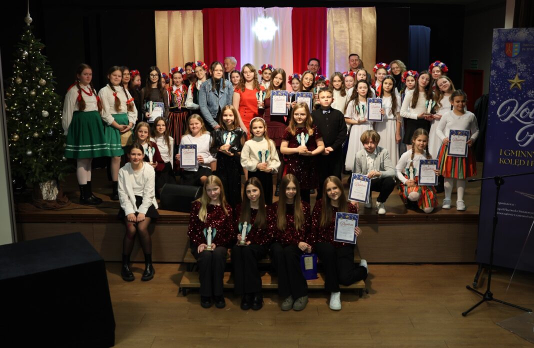 Grupa uczestników konkursu Kolędowy Flow w Gminie Morawica stojąca na scenie z dyplomami.
