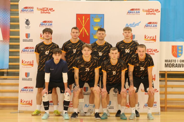 Zespół futsalowy w Morawickiej Lidze Futsalu na tle baneru hali sportowej.