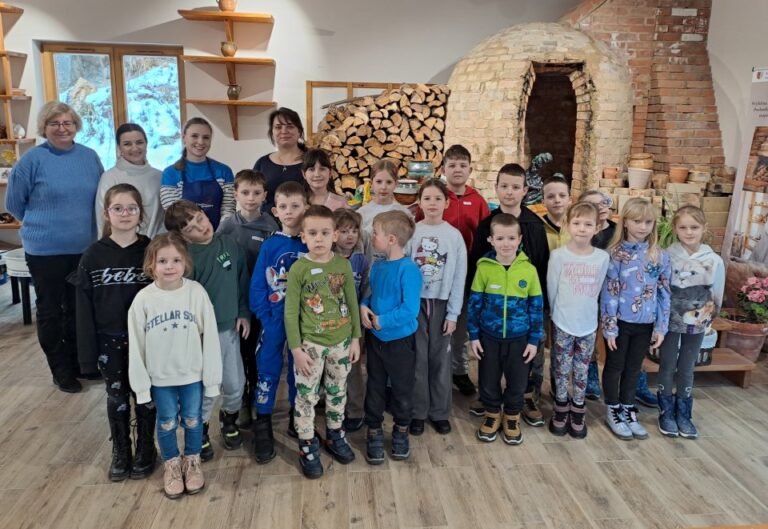 Grupa dzieci i dorosłych podczas warsztatów w Ośrodku Tradycji Garncarstwa w Chałupkach.
