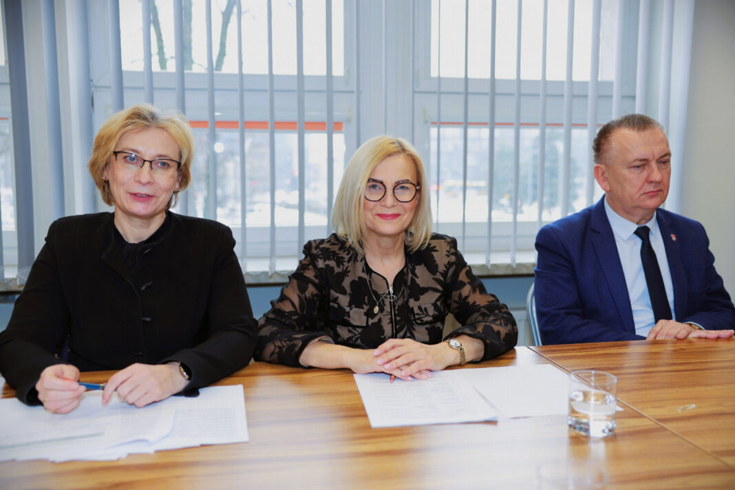 Trzy osoby siedzące przy stole na spotkaniu dotyczącym krwiodawstwa