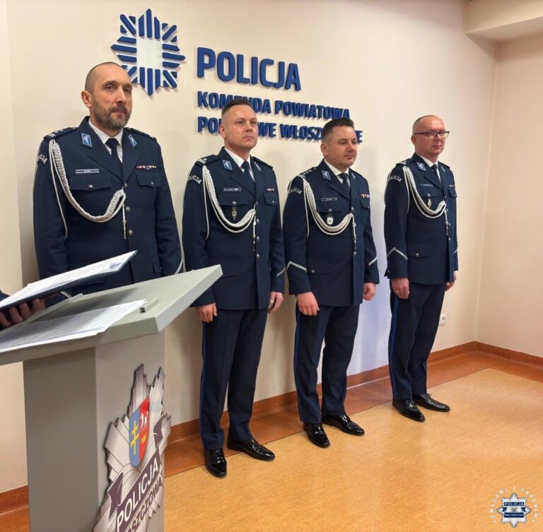 Czterech funkcjonariuszy policji stoi w mundurach przed logo Komendy Powiatowej Policji we Włoszczowie.