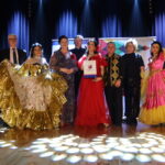 Grupa osób na scenie w strojach cygańskich podczas wydarzenia w Piekoszowie.