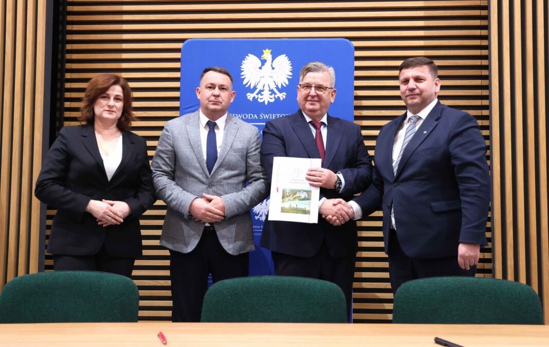 Cztery osoby na spotkaniu, podpisanie umowy na wsparcie opieki wytchnieniowej