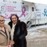 Dwie kobiety przed cytomammobusem oferującym bezpłatne badania mammograficzne i cytologiczne w Piekoszowie.