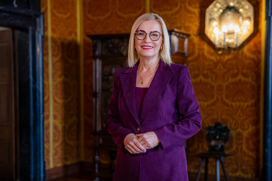 Kobieta w bordowym garniturze w eleganckim, stylowym wnętrzu