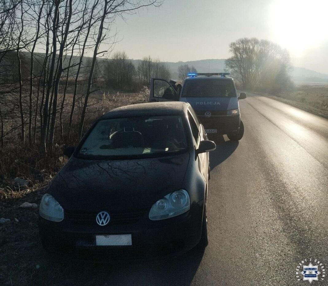 Kontrola drogowa z udziałem samochodu osobowego i radiowozu policyjnego na wiejskiej drodze o poranku.