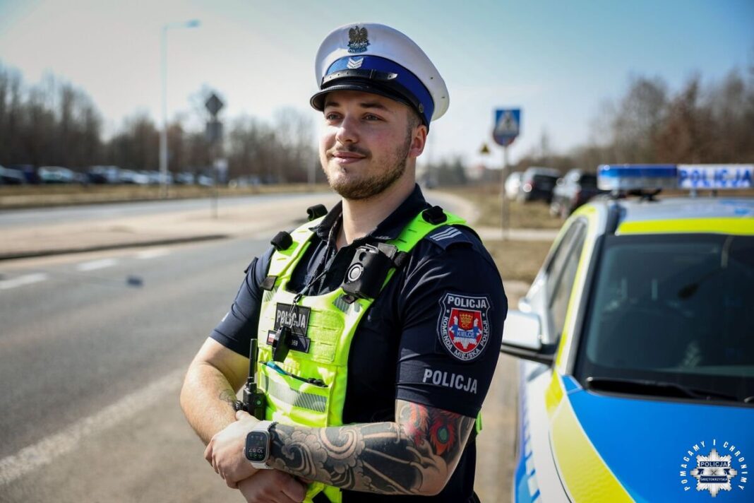 Policjant w umundurowaniu na tle radiowozu, zabezpieczenie targów Agrotech